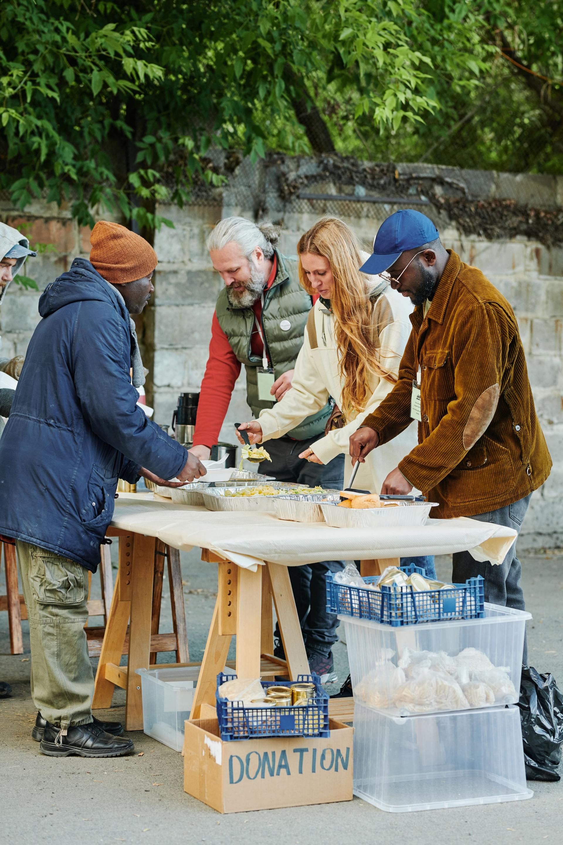 Volunteers feeding homeless people with food